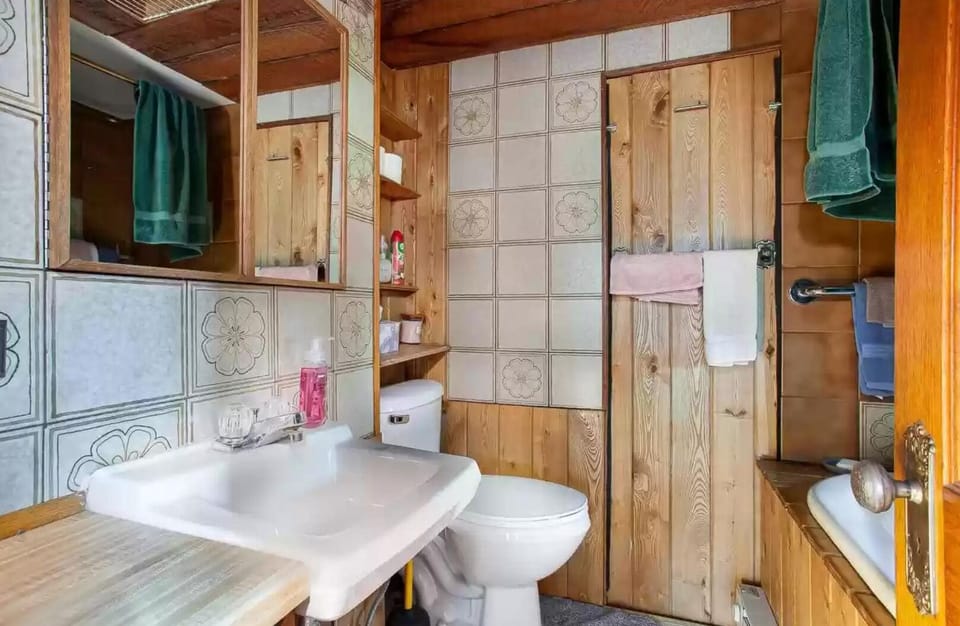 Small bathroom includes clawfoot tub with shower surround.
