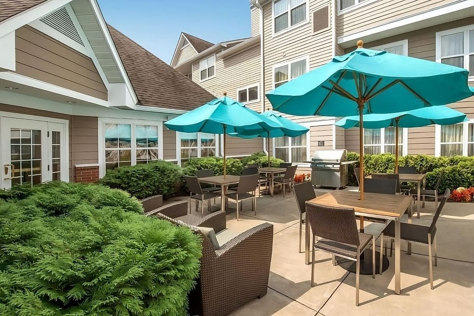 Sip coffee outside beneath umbrellas in a peaceful patio setting