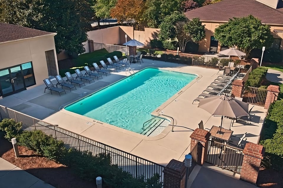 Dive into sunlit serenity with lounge chairs and sparkling water.