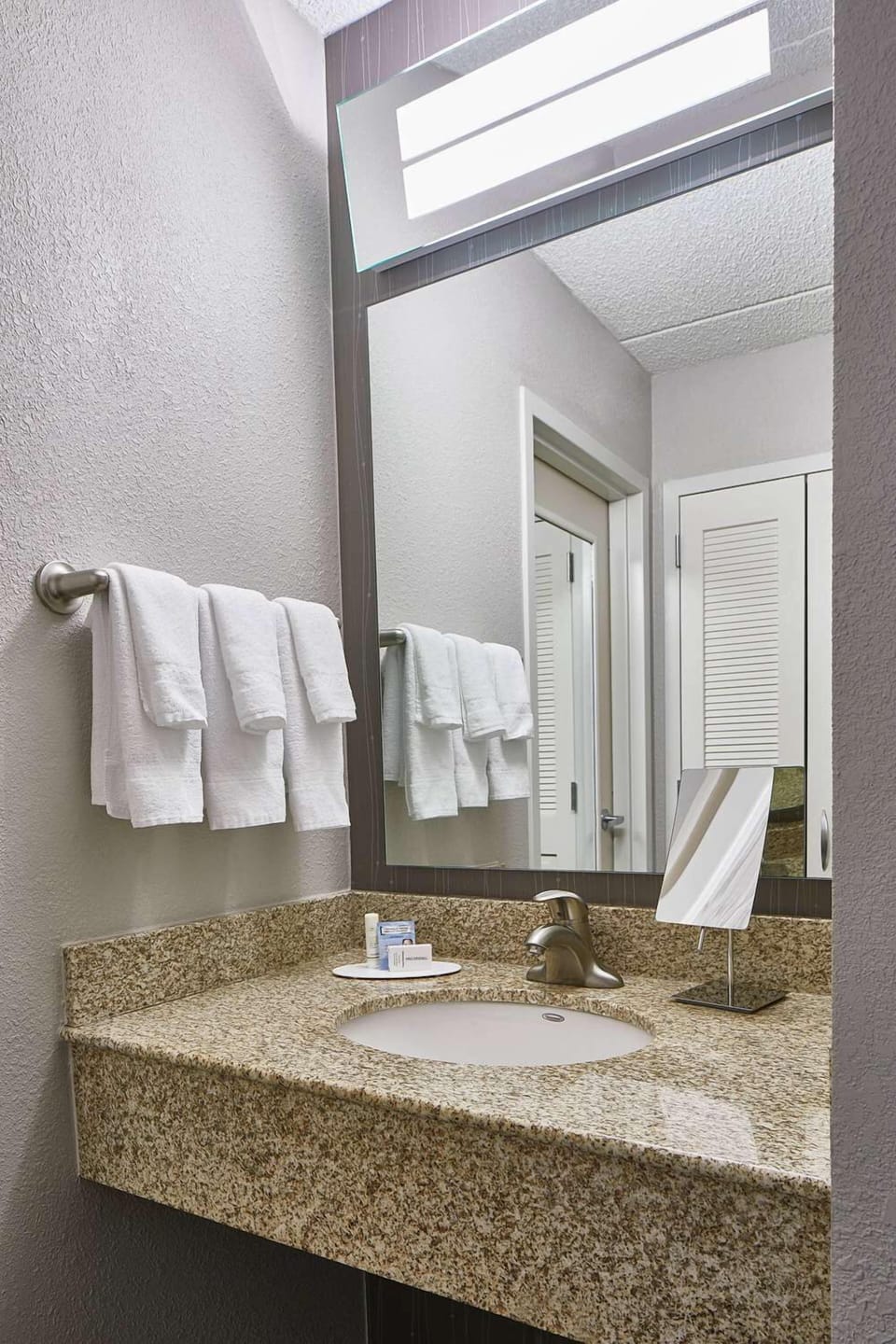 Refresh at the bright granite vanity with fluffy towels.