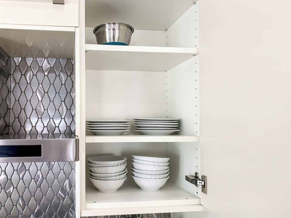 - Open the cabinet to find a full stack of plates and bowls for group dining ease
- Deep, textured bowls perfect for cereal, salads, or pasta night
- Clean organization and sleek cabinetry make meal prep a breeze