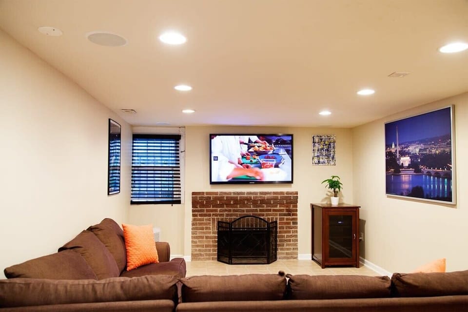 Well lit and spacious living room area with HD TV and surround sound