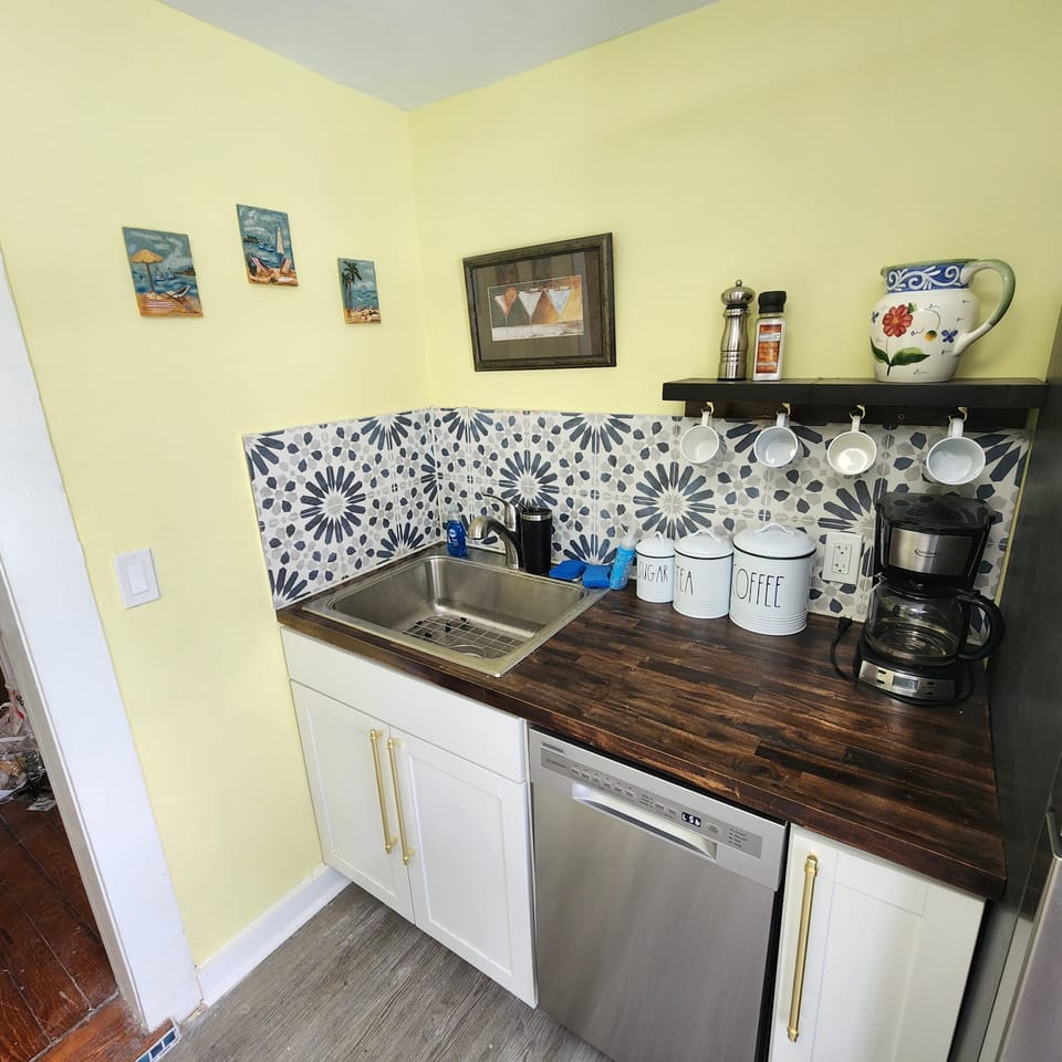 Coffee bar next to refrigerator.