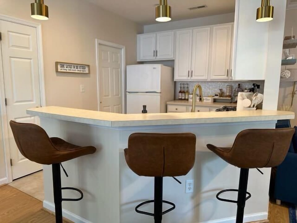 Fully stocked kitchen with barstools and spacious countertops