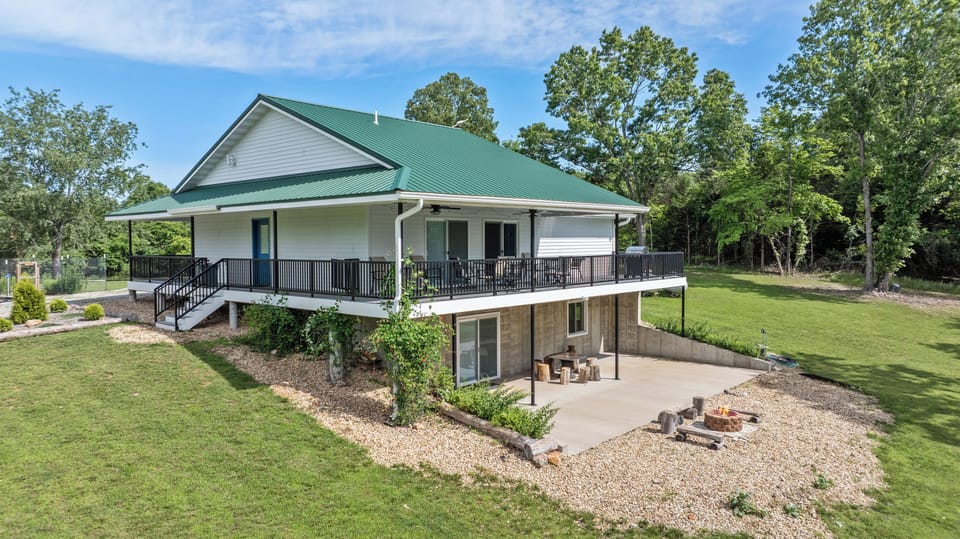 Two-level custom home with wraparound deck, covered patio, and fire pit.