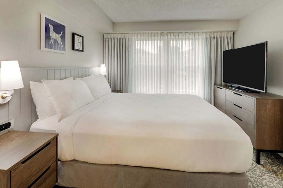 Unwind in a crisp king bed with calming light.