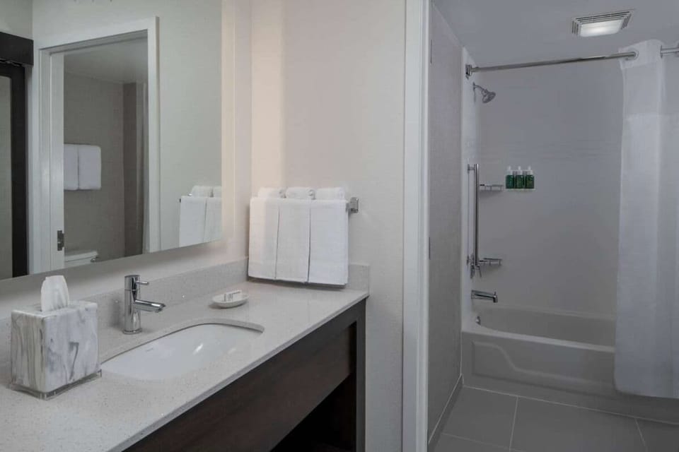 Refresh in a spotless bathroom with bright vanity lighting.