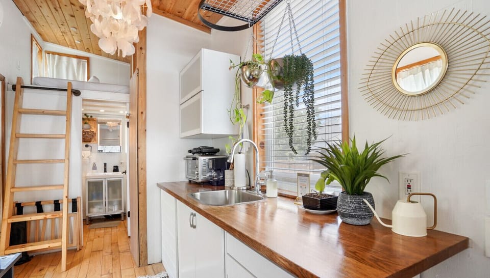 Kitchen with hot plate, toaster oven, coffee machine, and refrigerator.