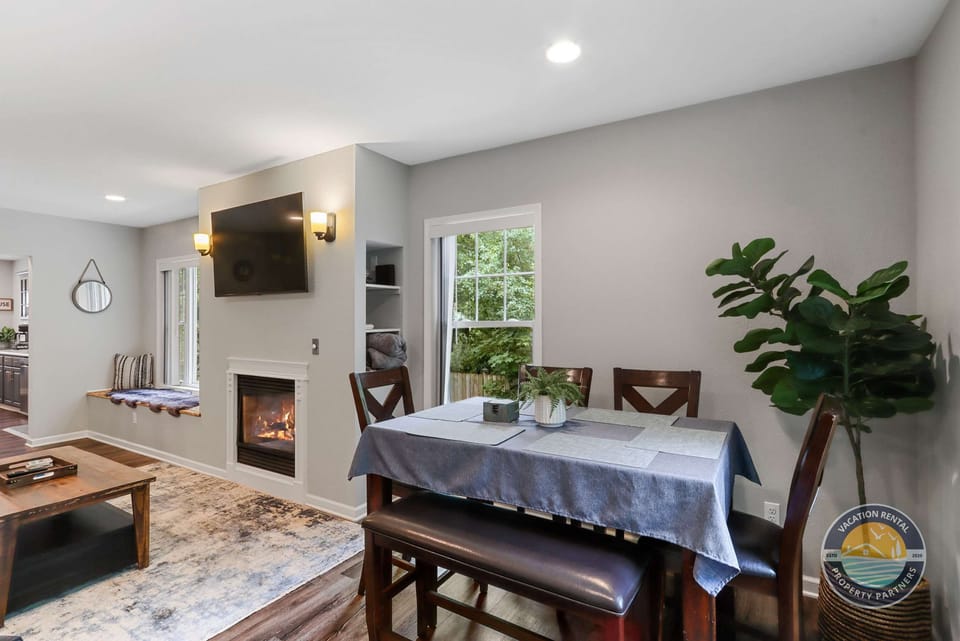 Gather around the dining table for shared meals and game nights, with the fireplace nearby adding warmth and comfort. A cozy space that connects seamlessly to the living area for easy entertaining.