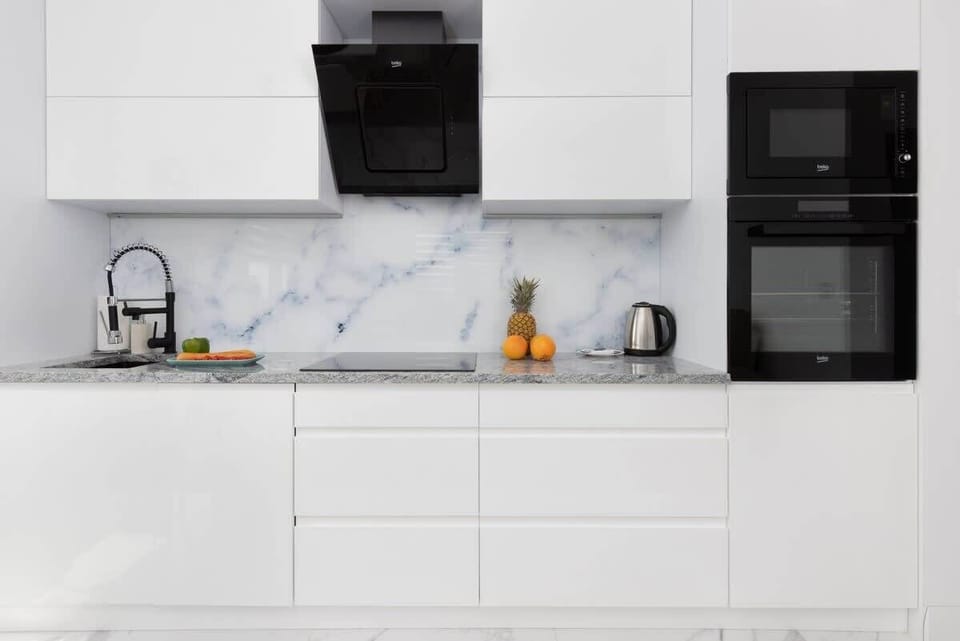 A closer perspective of the kitchen, featuring white cabinetry, high-quality appliances, and ample storage.





