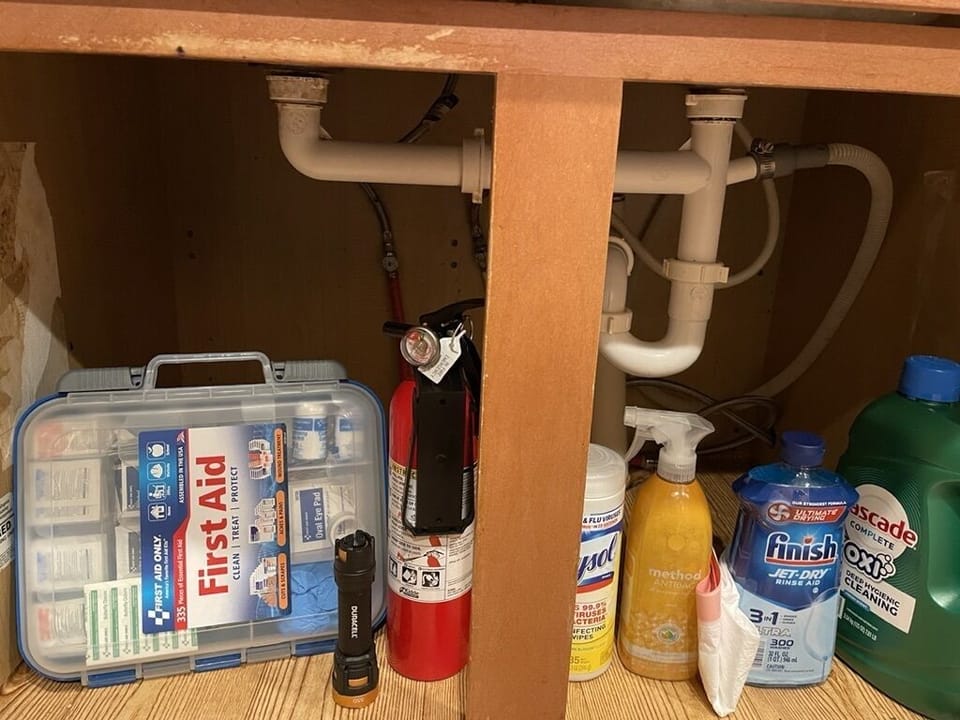 Under Kitchen Sink - First aid kit, flash light, and fire extinguisher
