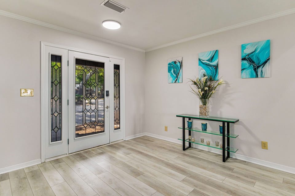 Welcoming entry with turquoise coastal artwork at Bayfront Bliss Gulf Breeze bayfront vacation rental near Pensacola Beach