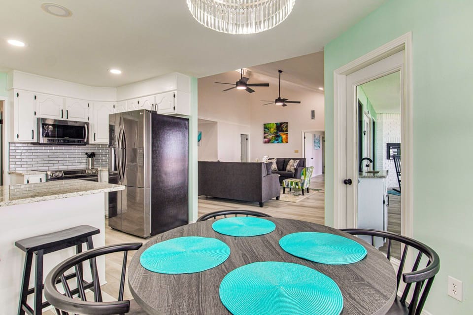 Dining room with crystal chandelier and wall of windows overlooking Pensacola Bay in Gulf Breeze Florida