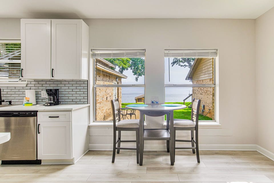 Bright dining area with bay views connects to kitchen at Bayfront Bliss Gulf Breeze bayfront vacation rental