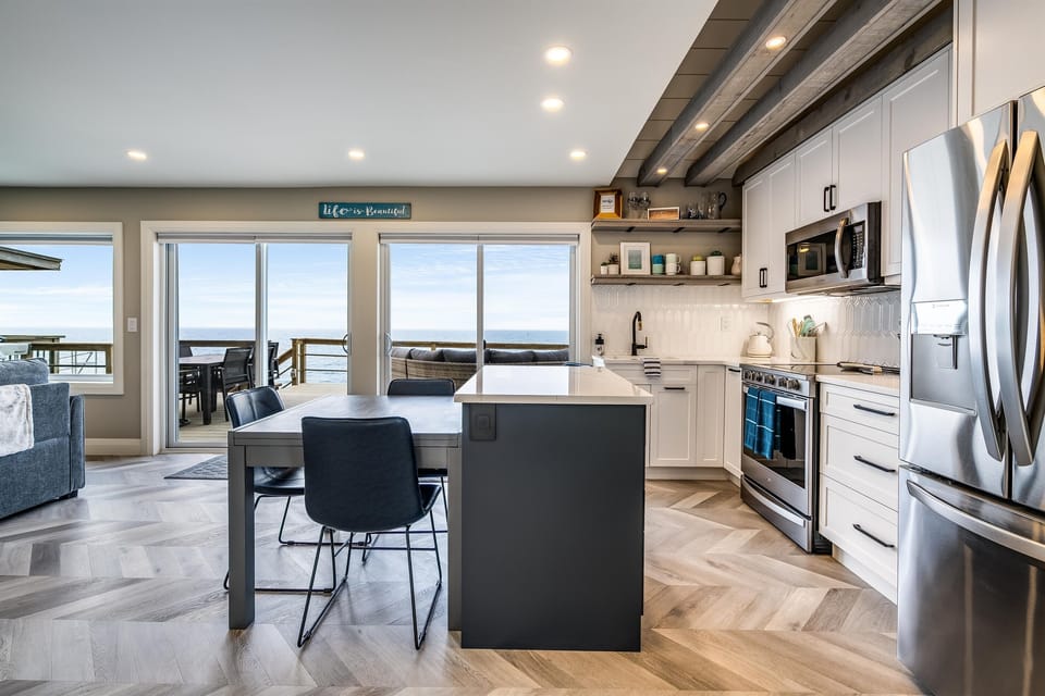 Fully equipped kitchen with stainless steel appliances including a dishwasher, microwave, fridge/freezer combo with water filter and ice maker, and an electric stove/oven combo.