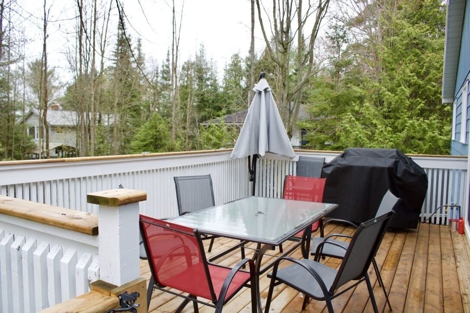 Back deck with stairs leading down to fire-pit.