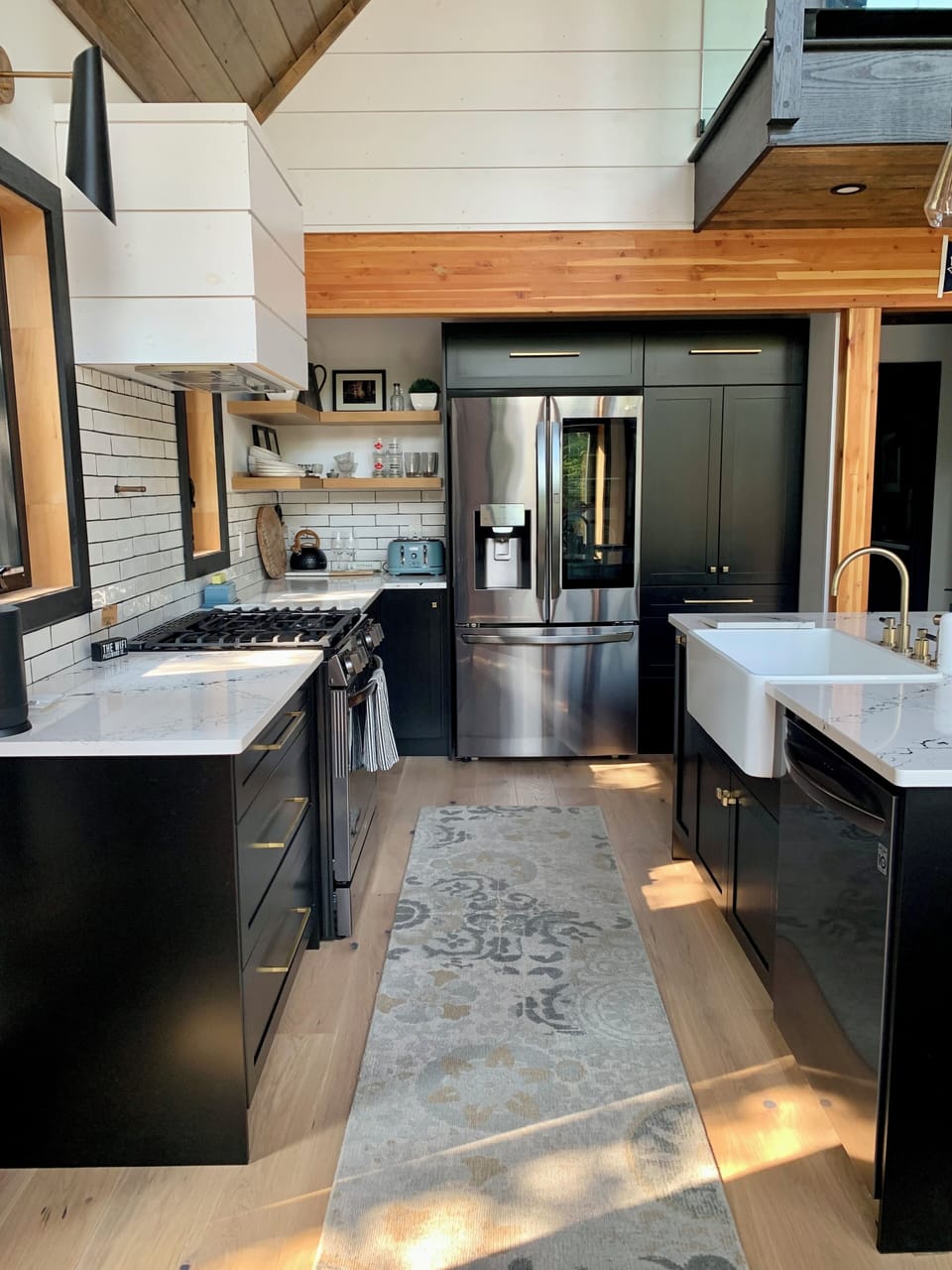 Black stainless LG appliances, farmhouse sink, brass fixtures.
