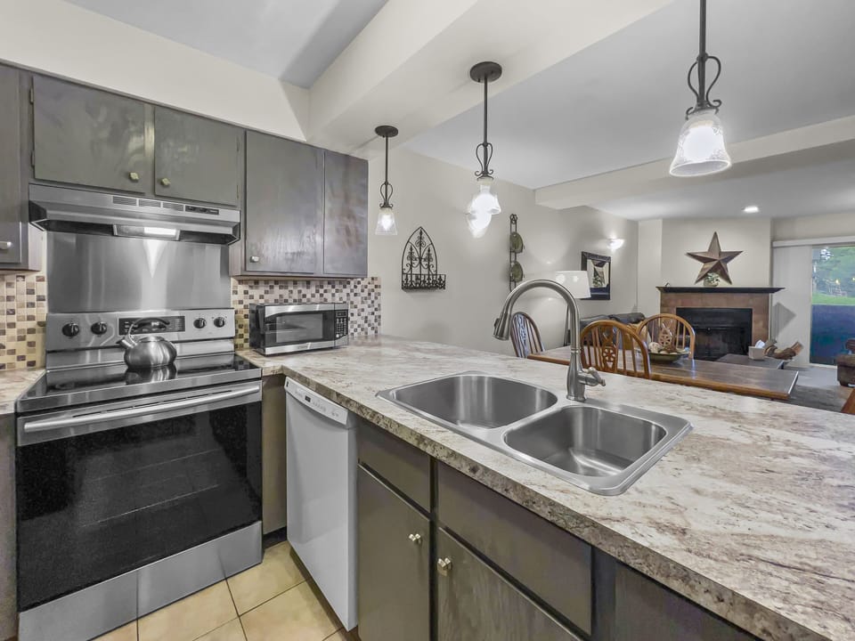 Prepare meals in our fully equipped kitchen, featuring stainless steel appliances, and modern white cabinets. All the essentials for a great stay.