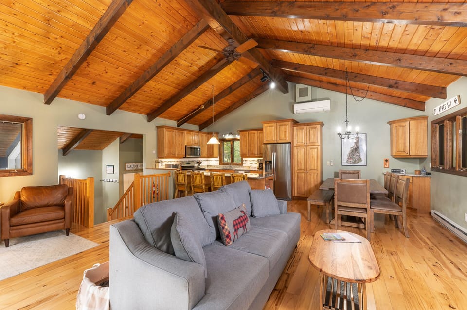 An open concept floor plan with high ceilings and exposed beams.