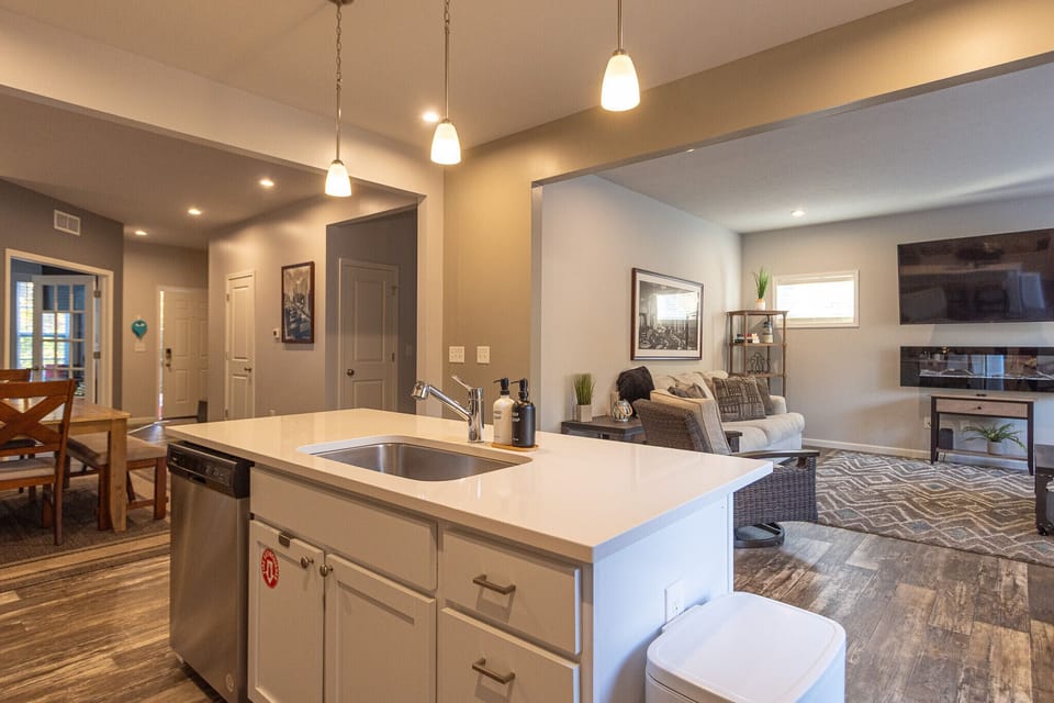 Open- concept main level at Harbor Pointe features a bright kitchen island overlooking the dining area and cozy living room