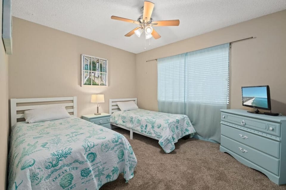 Upstairs, discover two twin beds adorned with charming nautical decor, featuring a TV for added entertainment during your stay!