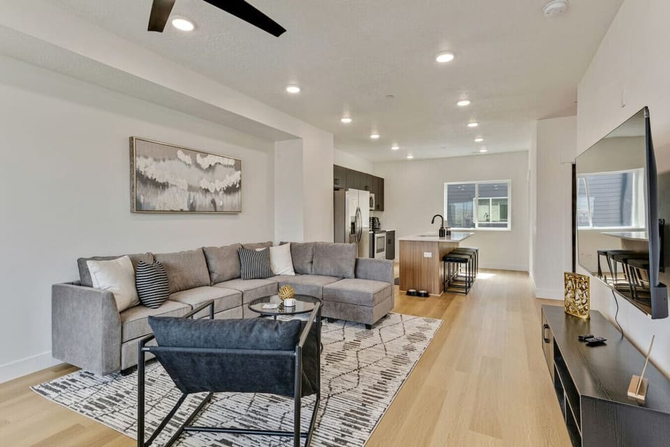 Open living space with sectional sofa, TV, and seamless flow into the modern kitchen—perfect for gathering 🍷🛋️✨