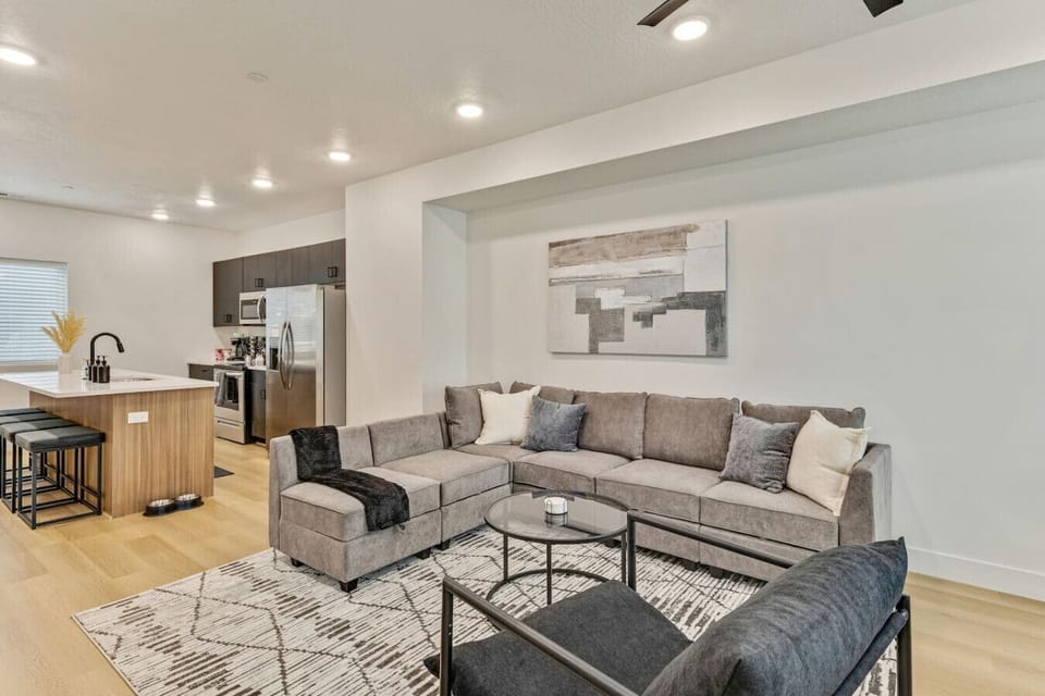 Open-concept living and dining with a cozy sectional and seamless flow into the modern kitchen 🍷✨🛋️
