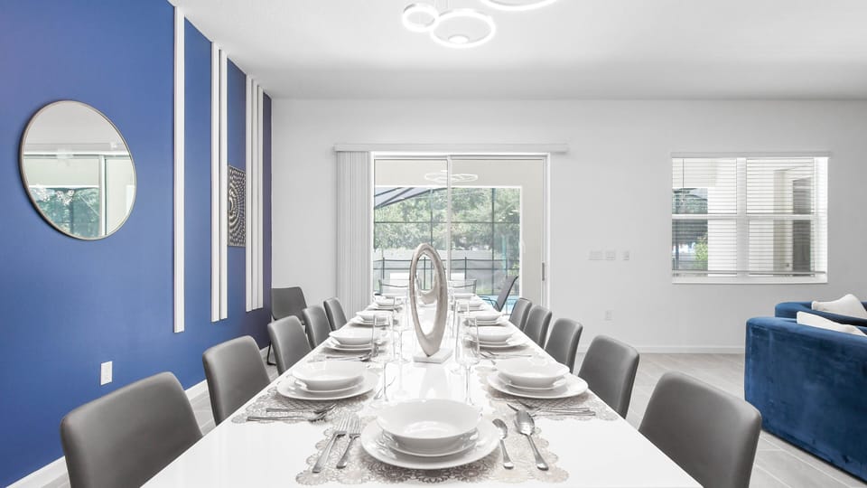 Elegant dining space with modern décor, seating for ten, and a view of the pool.