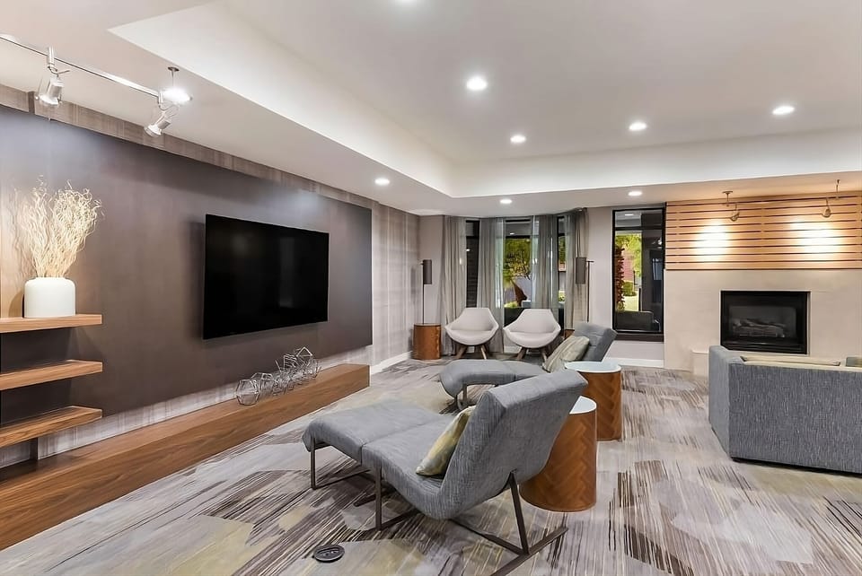 Unwind on plush seating by the glowing fireplace ambiance.