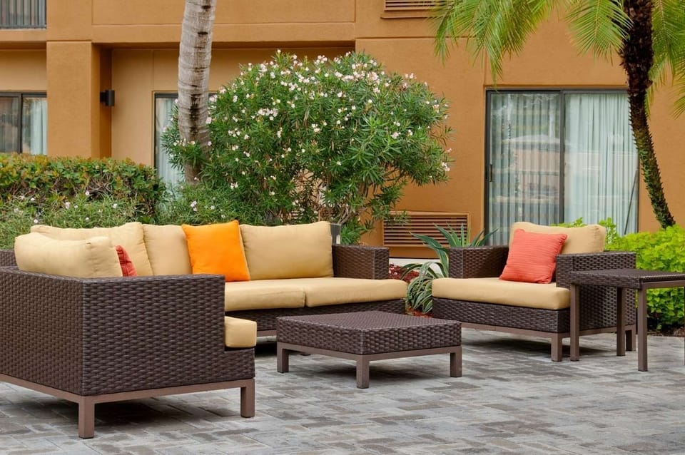 Unwind on cushioned wicker seating under warm tropical air.