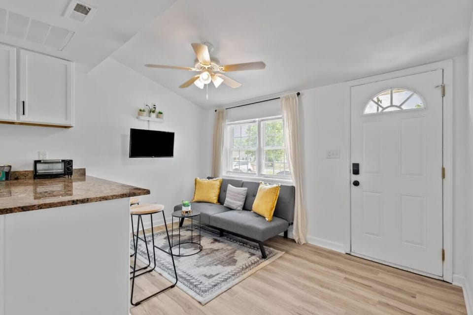 Bright, open-concept living space with Roku Smart TV & cozy seating.  Kick back and stream your favorite shows in this sunlit lounge, complete with ceiling fan and seamless flow into the kitchen and dining area.