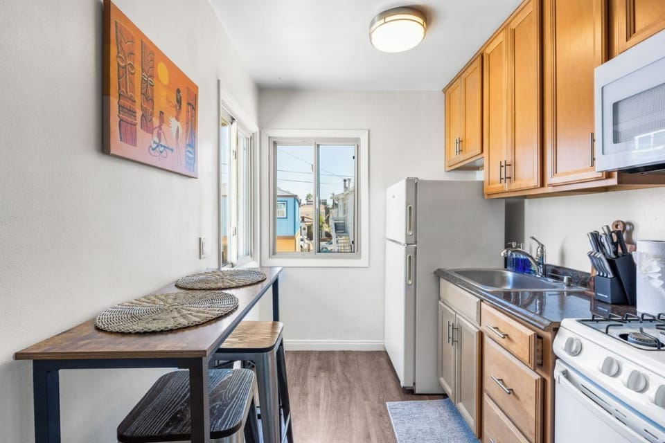 Kitchen - gas stove, microwave, fridge, blender, toaster, Keurig coffee maker, and coffee pods.