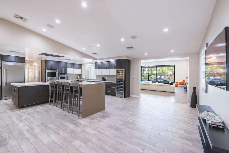 Modern kitchen with waterfall island, bar seating for six, and wine fridge