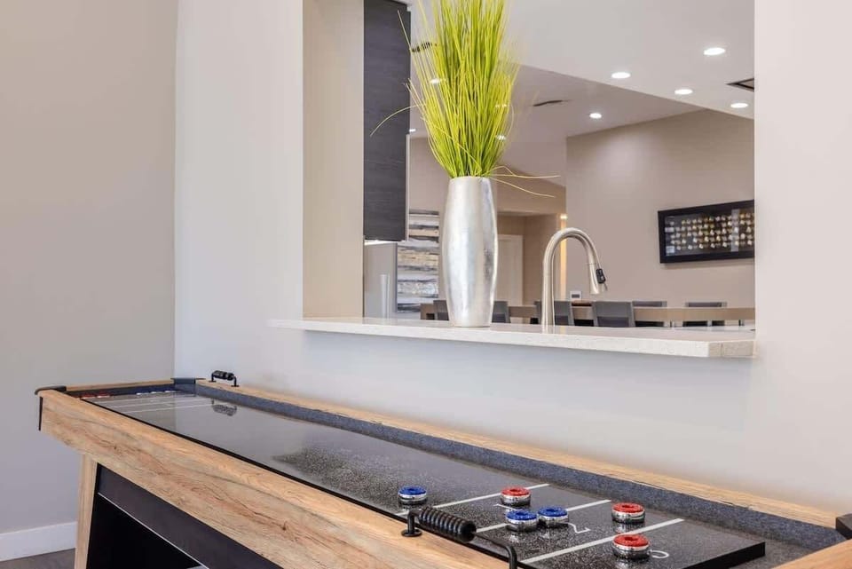 The shuffleboard table adds extra entertainment with a kitchen bar view in the background