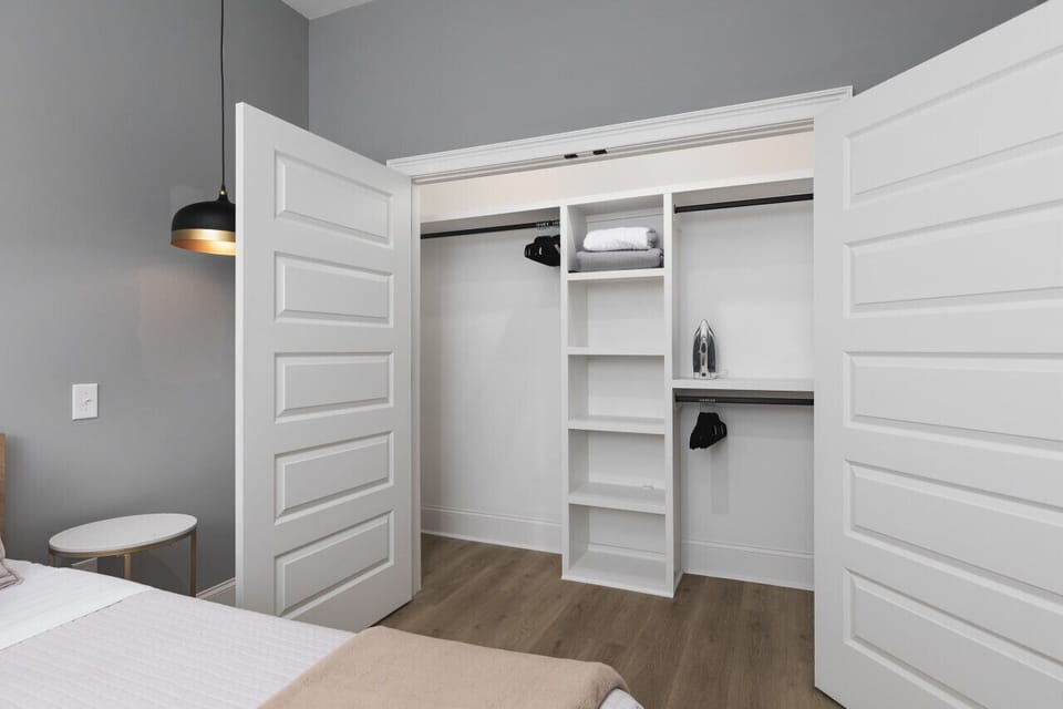 Bedroom #2 with a comfortable queen bed, custom lighting & decor, a Smart TV with all the streaming apps, and a huge closet to keep your clothes in.