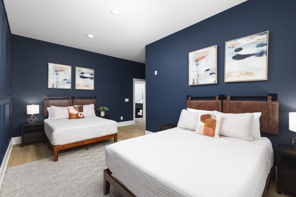 Primary bedroom with 1 Queen & 1 Full size beds, a full-length mirror and ensuite bathroom.