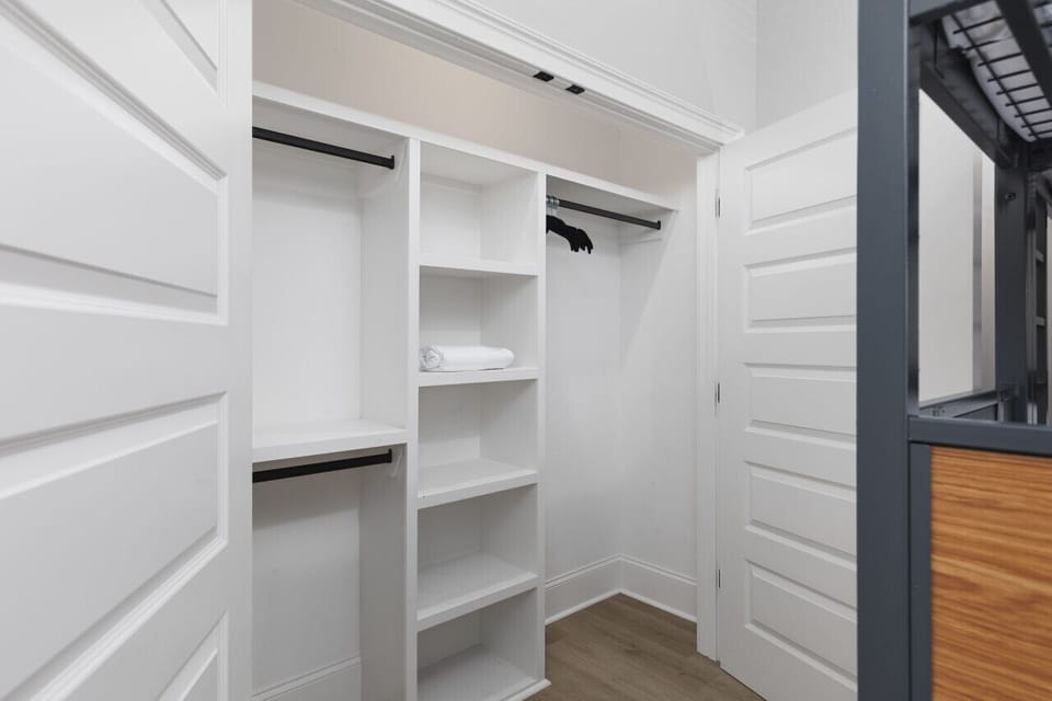 Bedroom #2 with triple queen bunk beds, a Smart TV, full-length mirror, and spacious closet.