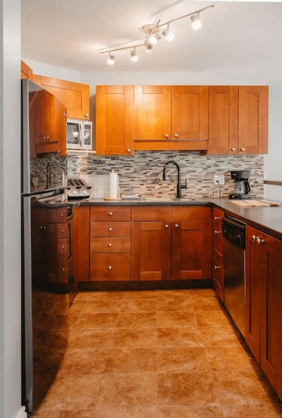 The fully stocked kitchen includes a fridge, dishwasher, microwave, toaster, coffee machine, stove, oven and sink.