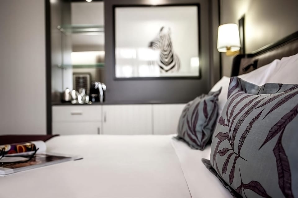 Sink into crisp linens with plush pillows and warm lighting.