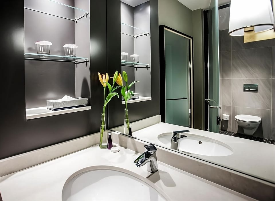 Refresh at the sleek vanity with bright mirrors and storage.