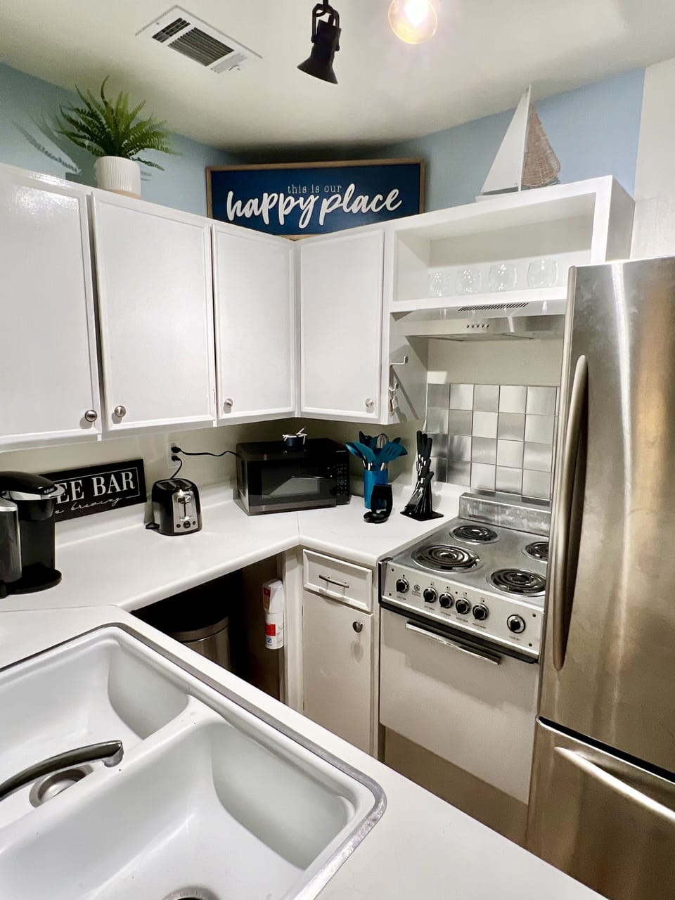 kitchen stocked with paper towels, pots, pans, knives, dishes and utensils.