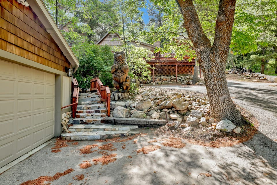 Welcoming cabin entry surrounded by towering pine trees, offering fresh mountain air and a peaceful forest setting—the perfect first impression for your Big Bear Lake getaway.