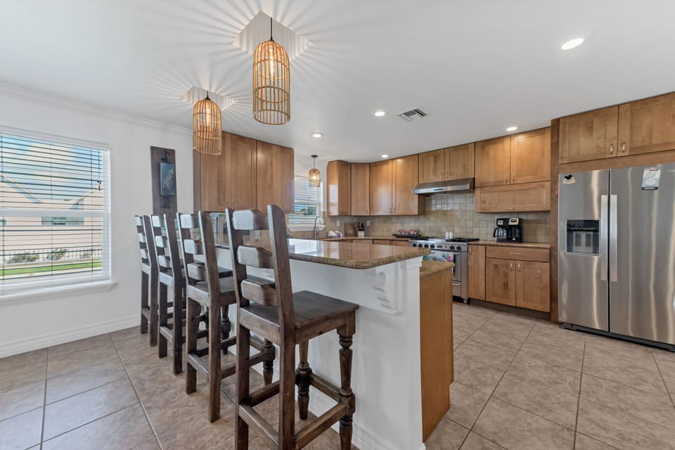 Your spacious kitchen features warm wood cabinetry, granite countertops, and a breakfast bar perfect for morning coffee conversations.