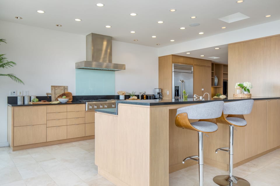 Fully-equipped kitchen with modern appliances and barstool seating at the island counter.