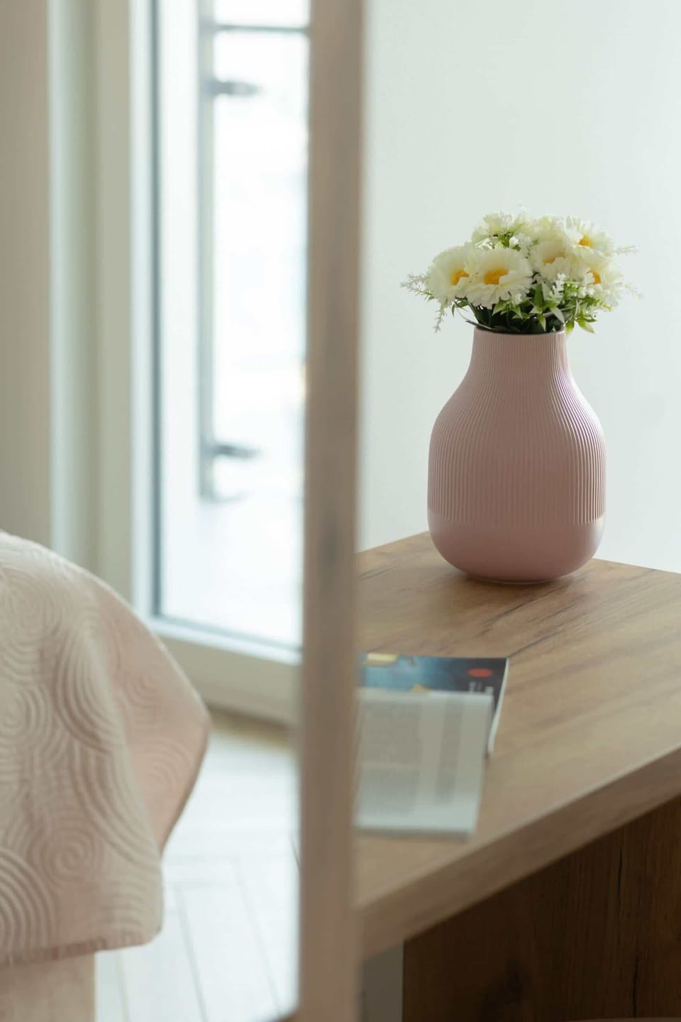 A decorative side table with a flower vase, adding charm to the bedroom's decor.
