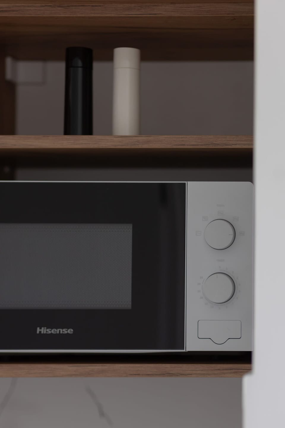 A close-up of a built-in microwave and open shelving for storage, adding practicality to the kitchen.
