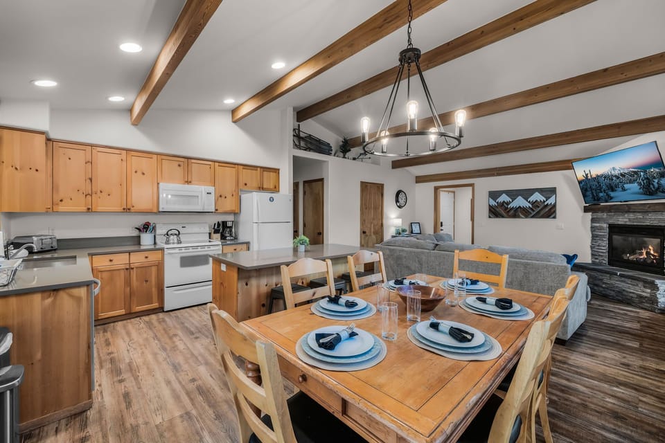 Gather around your spacious dining table beneath stunning exposed beams, with a fully equipped kitchen and cozy fireplace creating the perfect mountain retreat atmosphere.