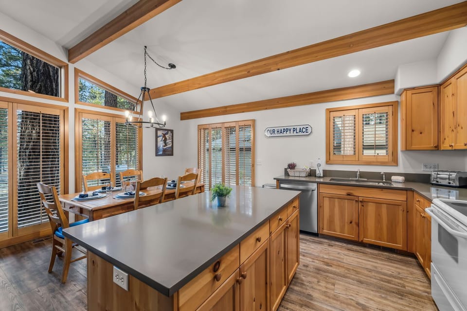 Your spacious kitchen welcomes you with warm wood beams, gleaming countertops, and panoramic windows that flood the space with natural light.