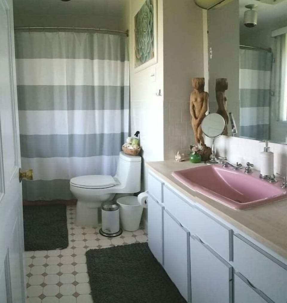 Master bathroom with view over harbor. It has a sink, bathtub, shower and toilet