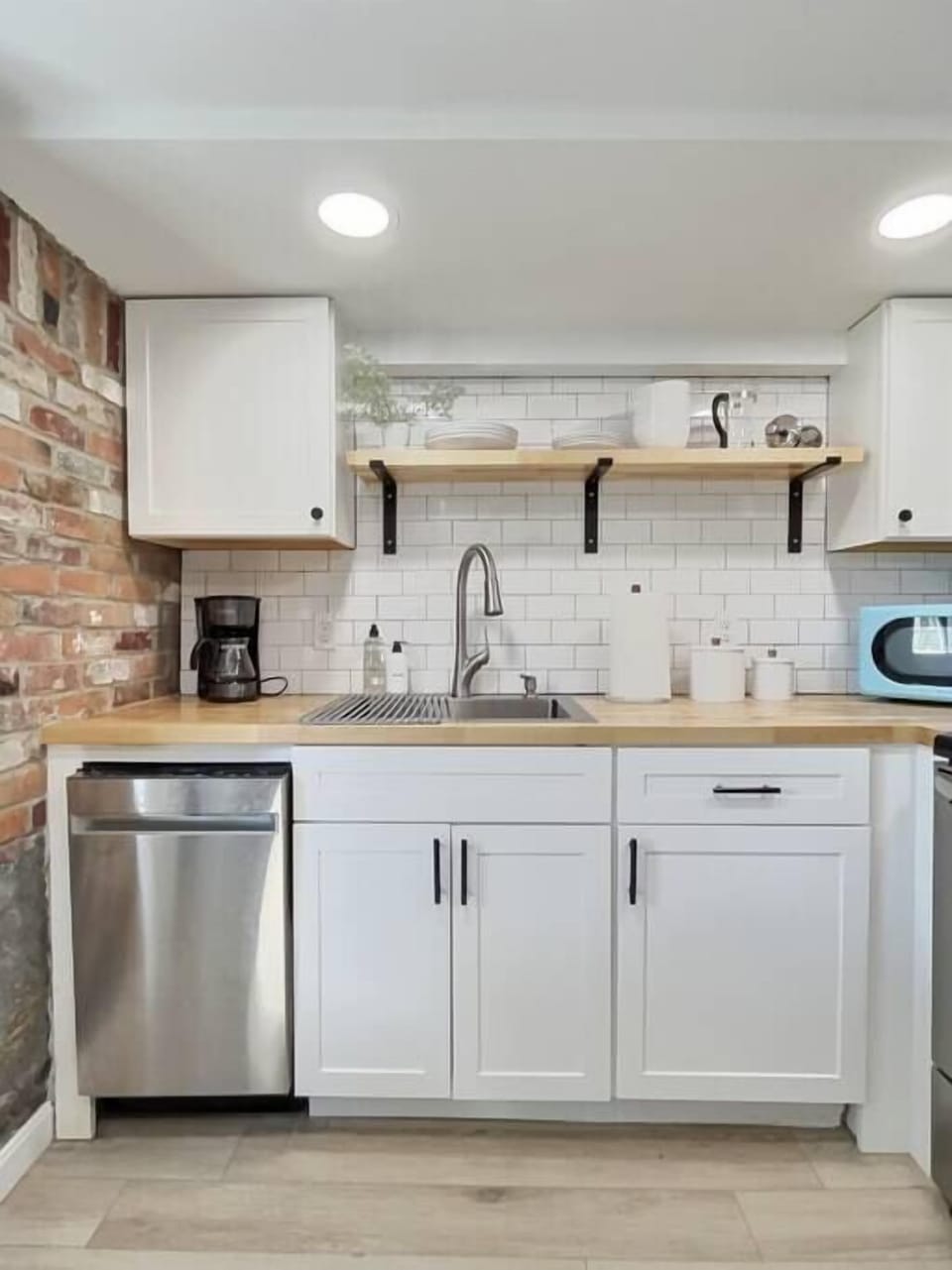 Bright kitchen with stainless steal appliances and butcher block counter tops.